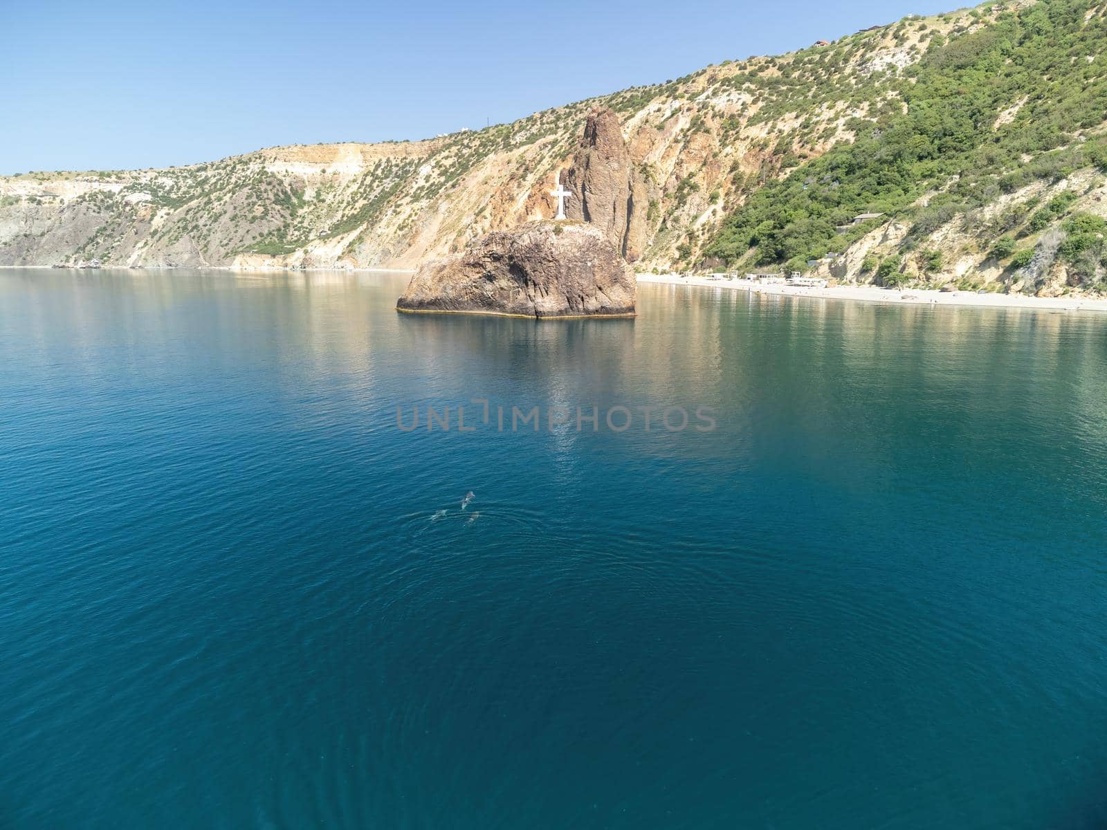 Sea landscape with rocky coastline on sunset time with cloudy sky. Yachts in the Sea on a background of rocky shores. The concept of perfect place for summer travel and rest.