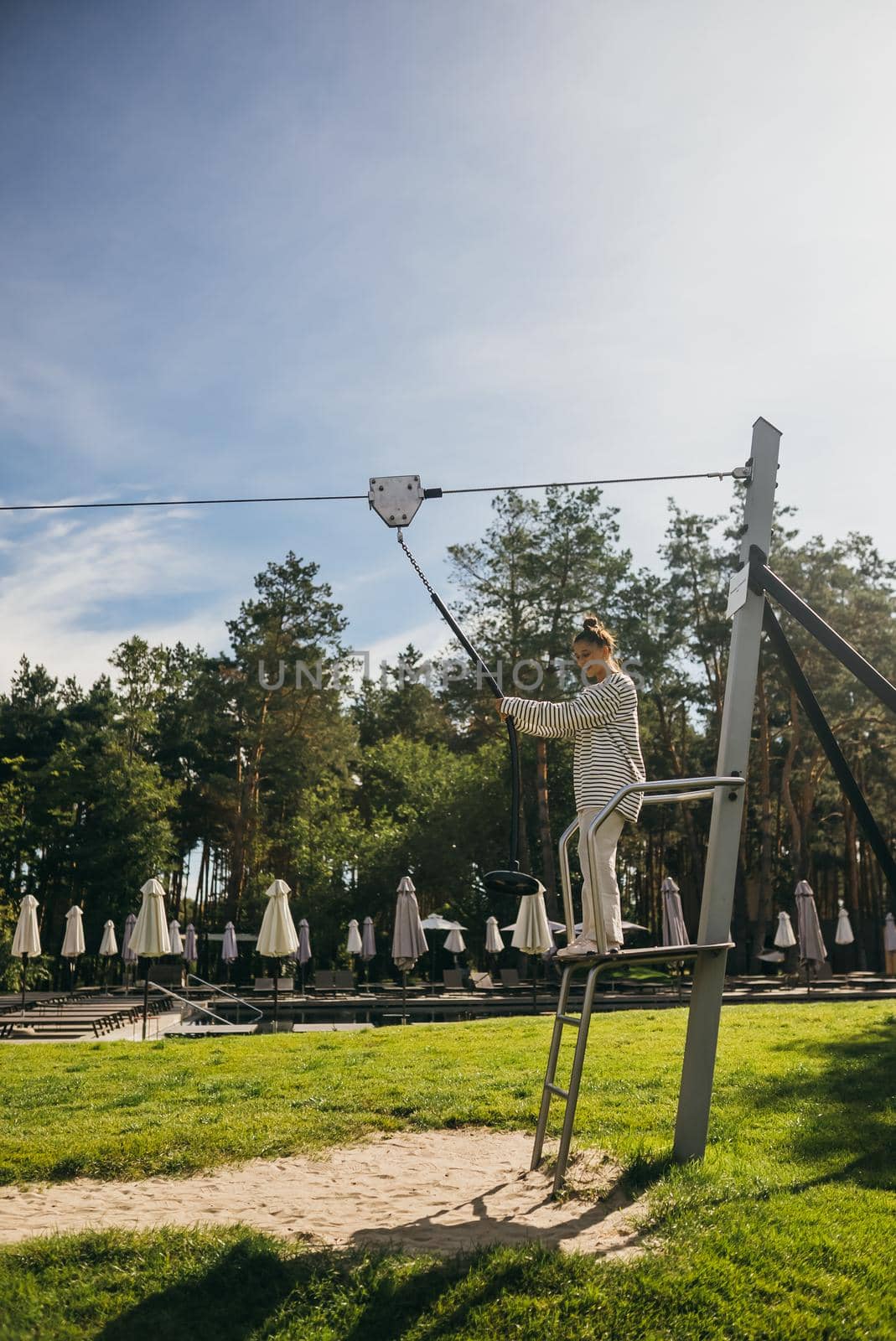 A young woman wants to go bungee from the tower in the rope park