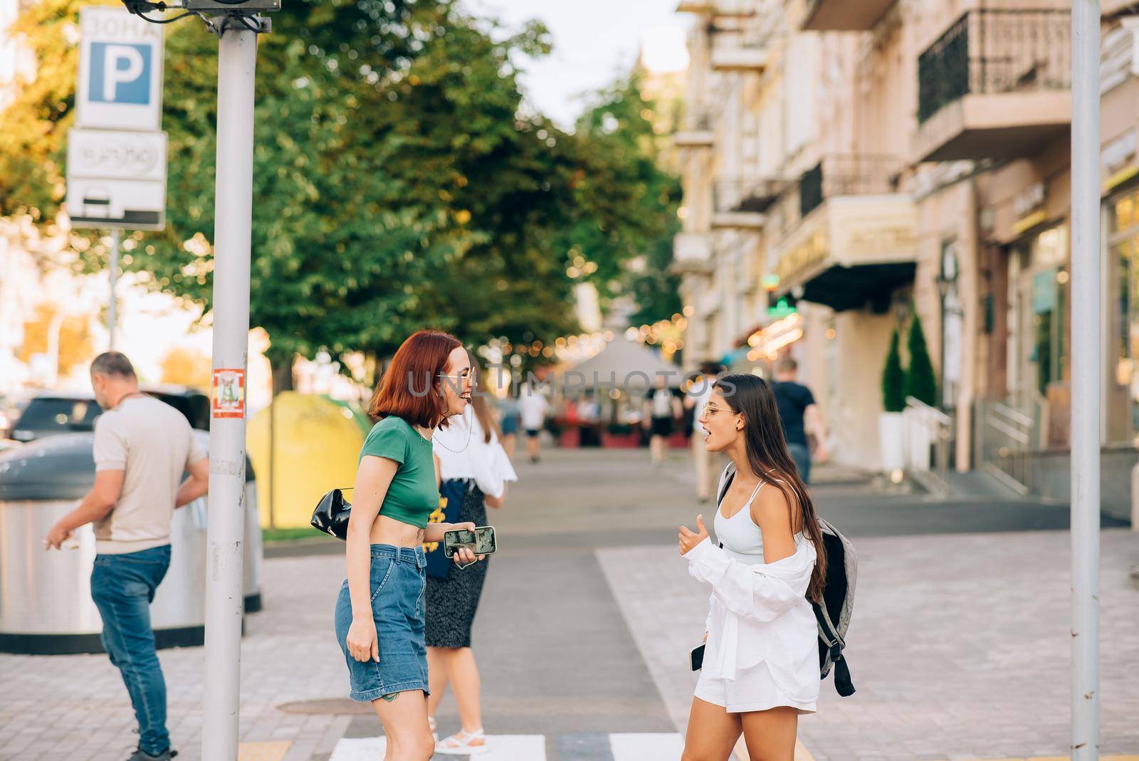 Happy women talking and laughing at the city street by teksomolika