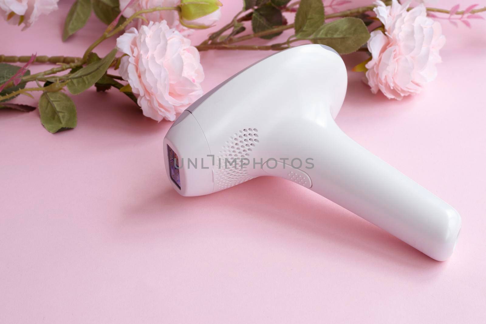 home modern laser epilator. Hair Remover offering Permanently Smooth Skin. Flash Epilator Laser on a pink background. Female blog concept. High quality photo