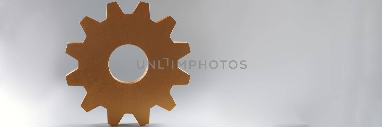 Close-up of large wooden gear on grey background, single mechanism for integrated development. Part of large complex system. Think process, idea concept