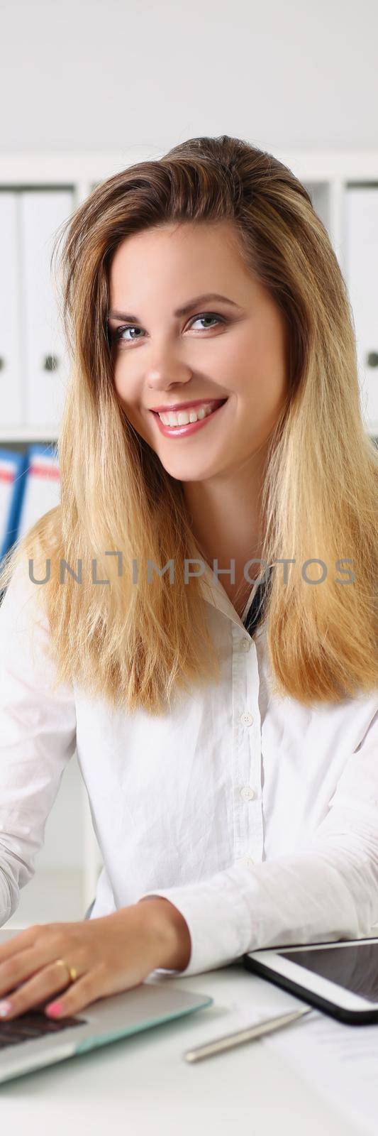 Cheerful young office worker sit on working place, search information online by kuprevich