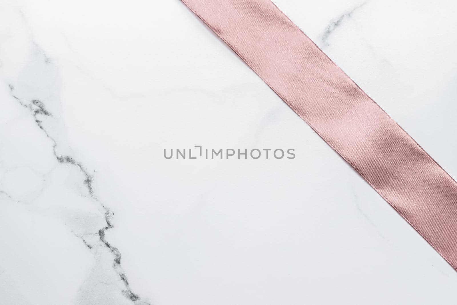 Birthday, wedding and girly branding concept - Beige silk ribbon and bow on marble background, glamour present mockup and fashion gift decoration for luxury beauty brand holiday flatlay design