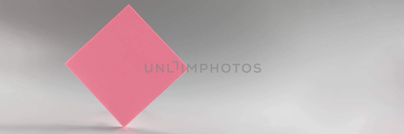 Pink sticker standing on sharp edge on grey background by kuprevich