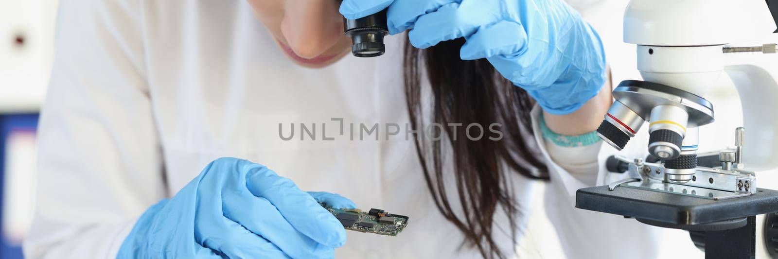Woman examine part of digital device with magnifying glass by kuprevich