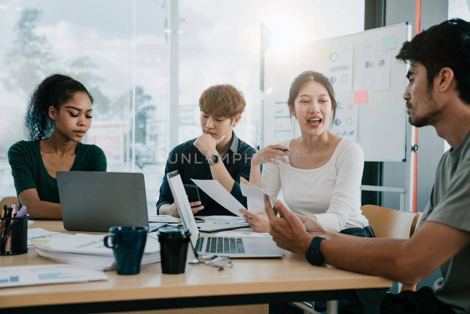 Creative diversity business team at table in a modern startup office. female speaker offers a great idea and the team supports.