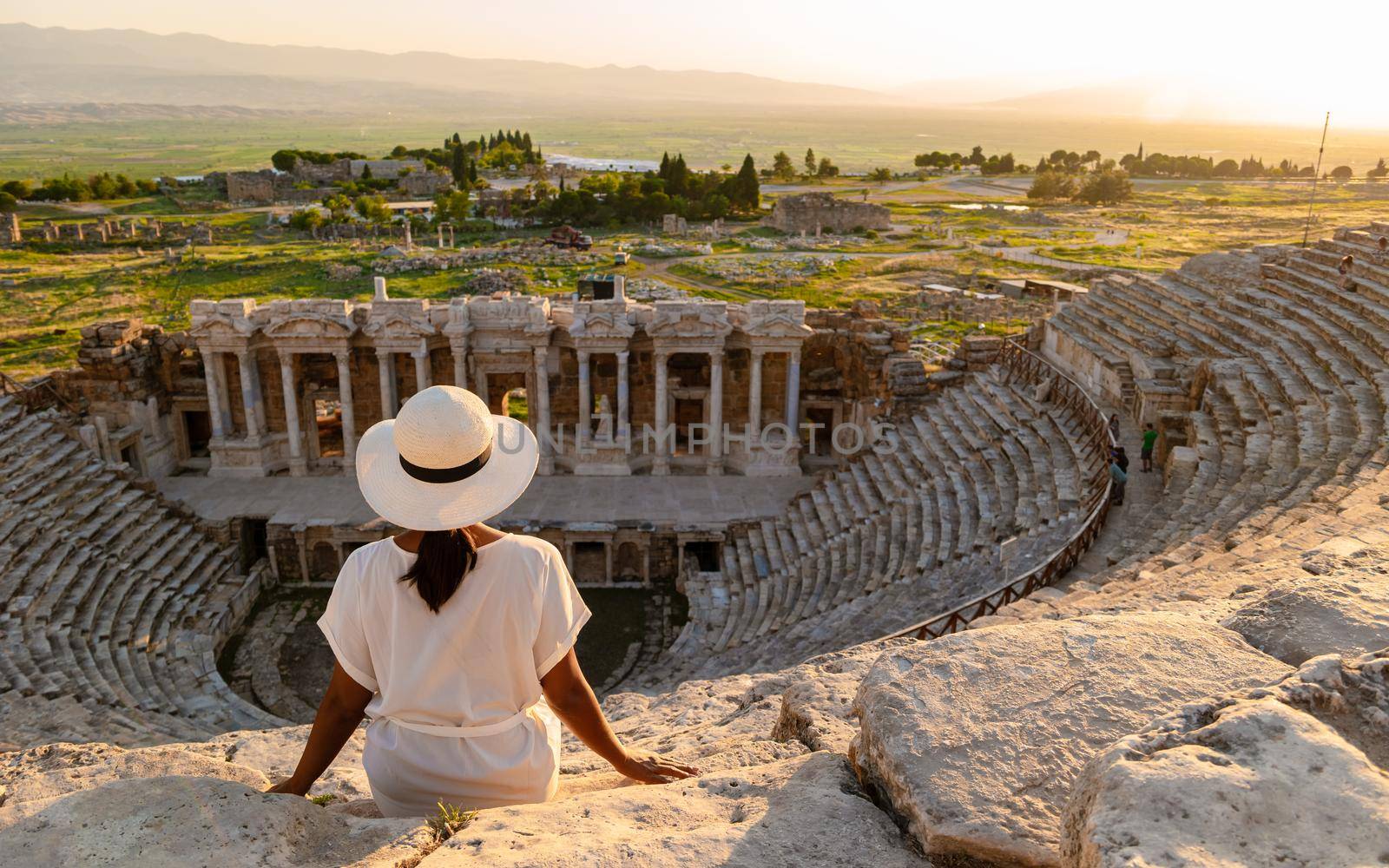 Hierapolis ancient city Pamukkale Turkey, sunset by the ruins Unesco site, Hierapolis ancient city Pamukkale Turkey Young Asian women with hat watching the sunset at Hierapolis Pamukkale