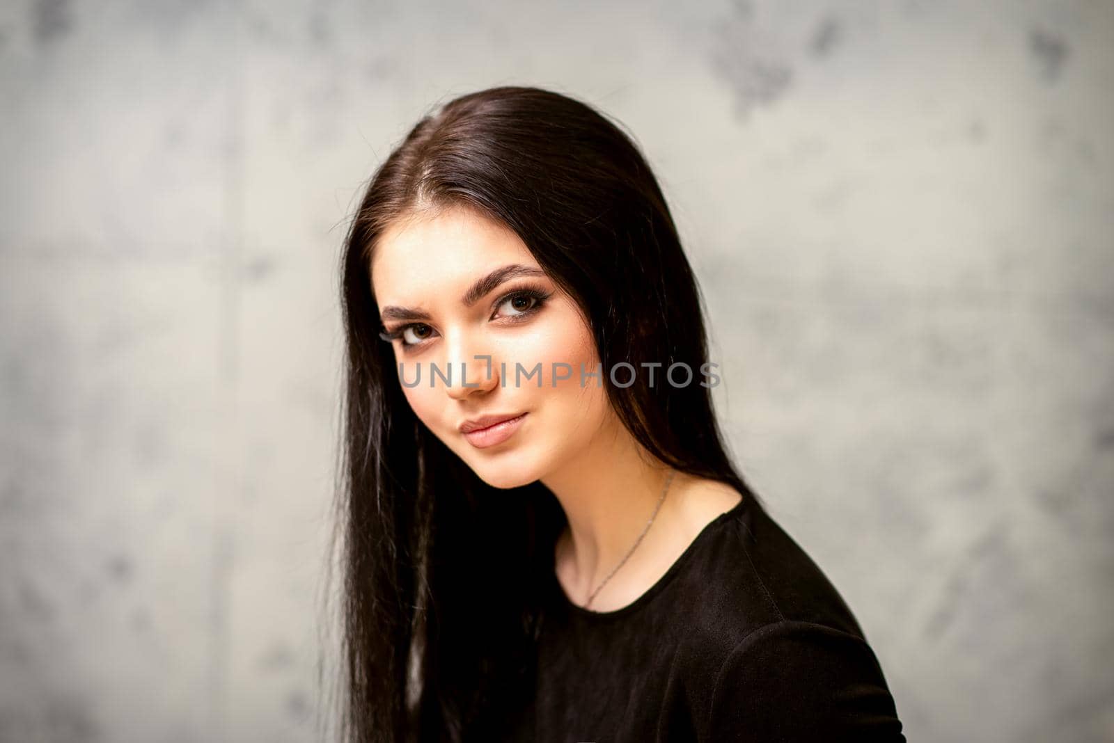 The fashionable young woman. Portrait of the beautiful female model with long hair and makeup. Beauty young caucasian woman with a black hairstyle. by okskukuruza