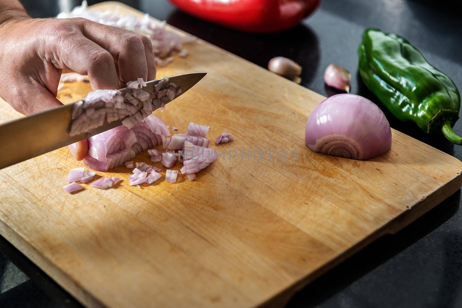 chef chopping onions on a cutting board by raulmelldo