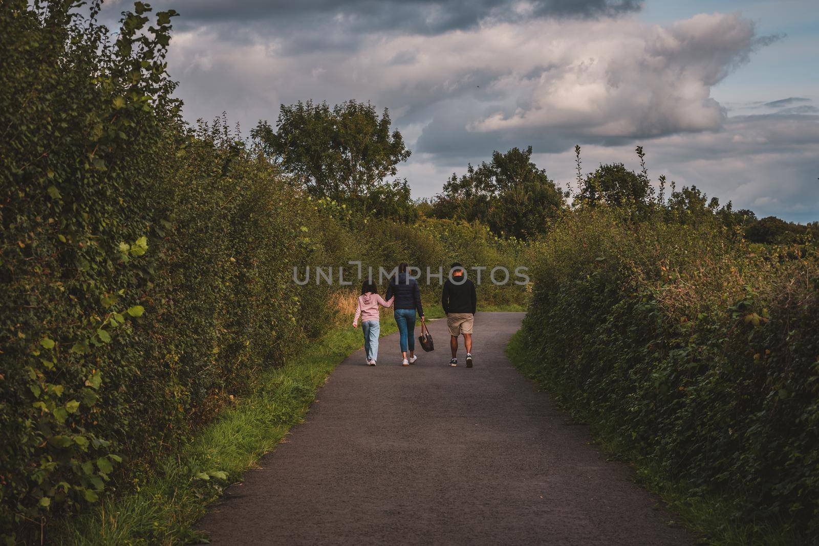 Family walking in path towards the woods by fabioxavierphotography