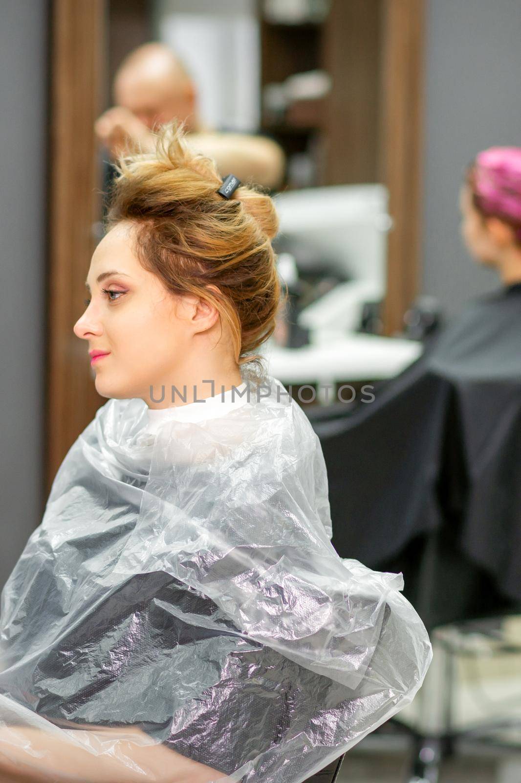 Beautiful young blonde caucasian woman in the modern hair salon. by okskukuruza