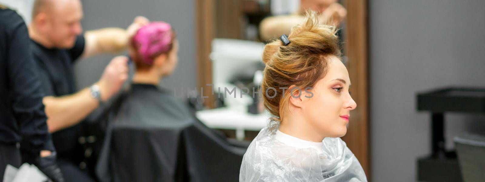 Beautiful young blonde caucasian woman in the modern hair salon. by okskukuruza