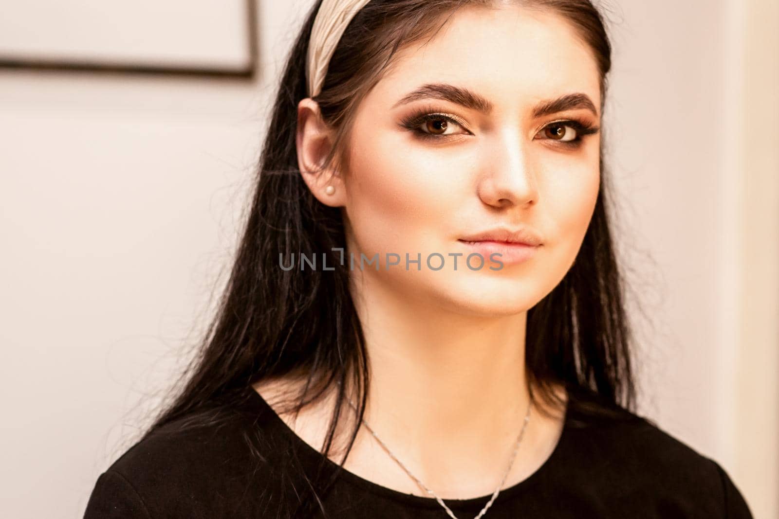 The fashionable young woman. Portrait of the beautiful female model with long hair and makeup. Beauty young caucasian woman with a hoop on her head