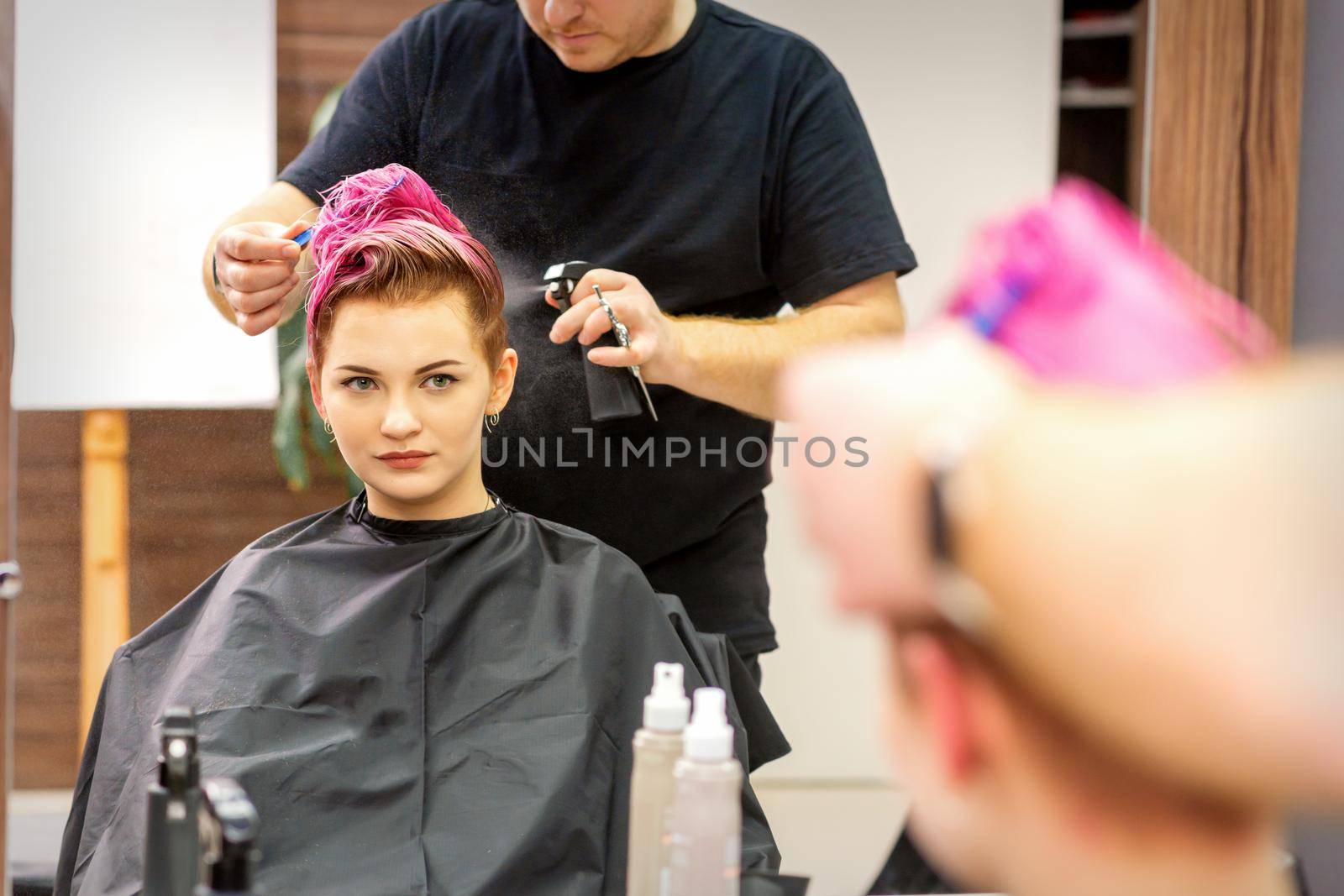 Beautiful young pink haired caucasian woman in the modern hair salon. by okskukuruza