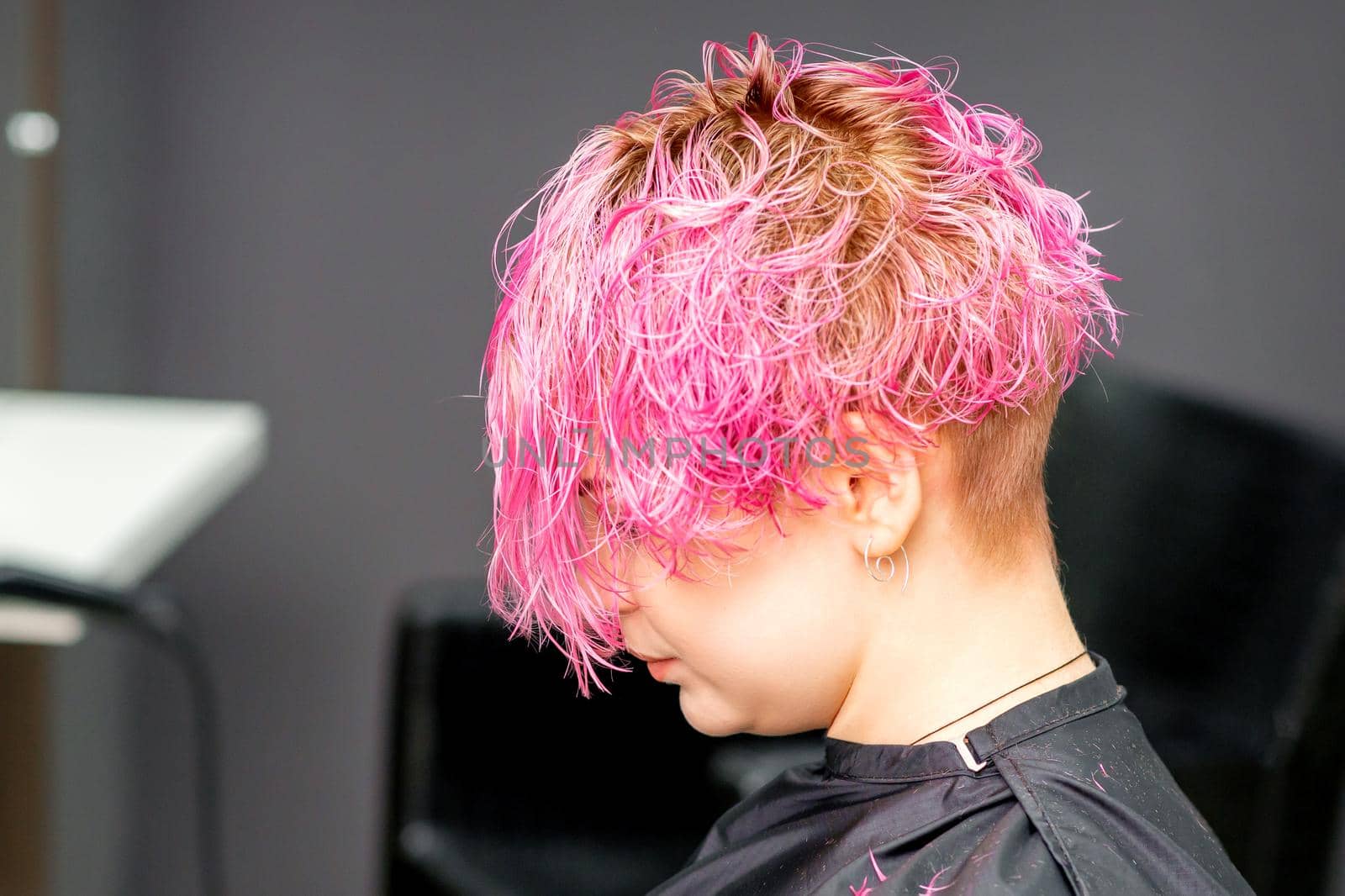 Beautiful young pink haired caucasian woman in the modern hair salon