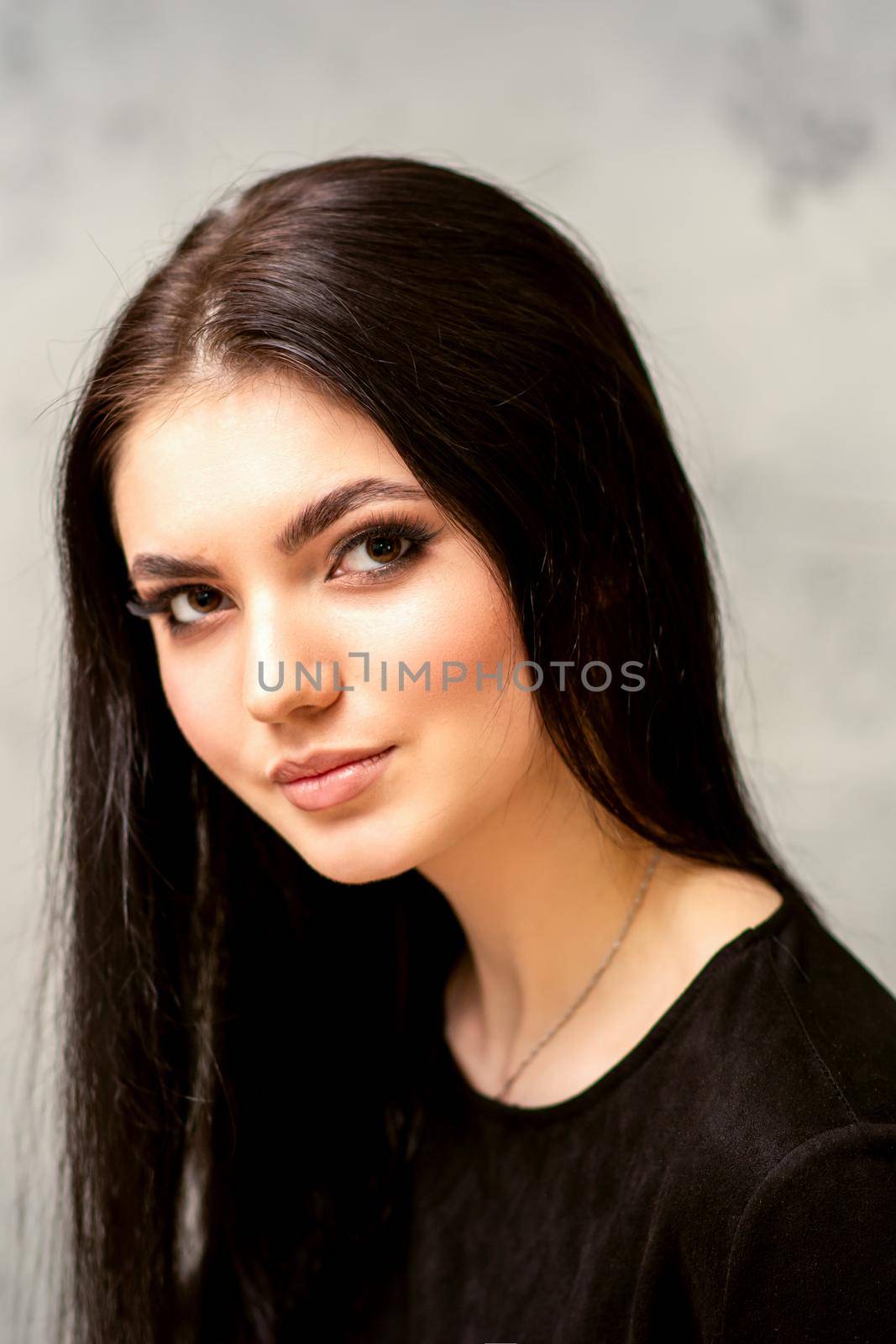 The fashionable young woman. Portrait of the beautiful female model with long hair and makeup. Beauty young caucasian woman with a black hairstyle. by okskukuruza