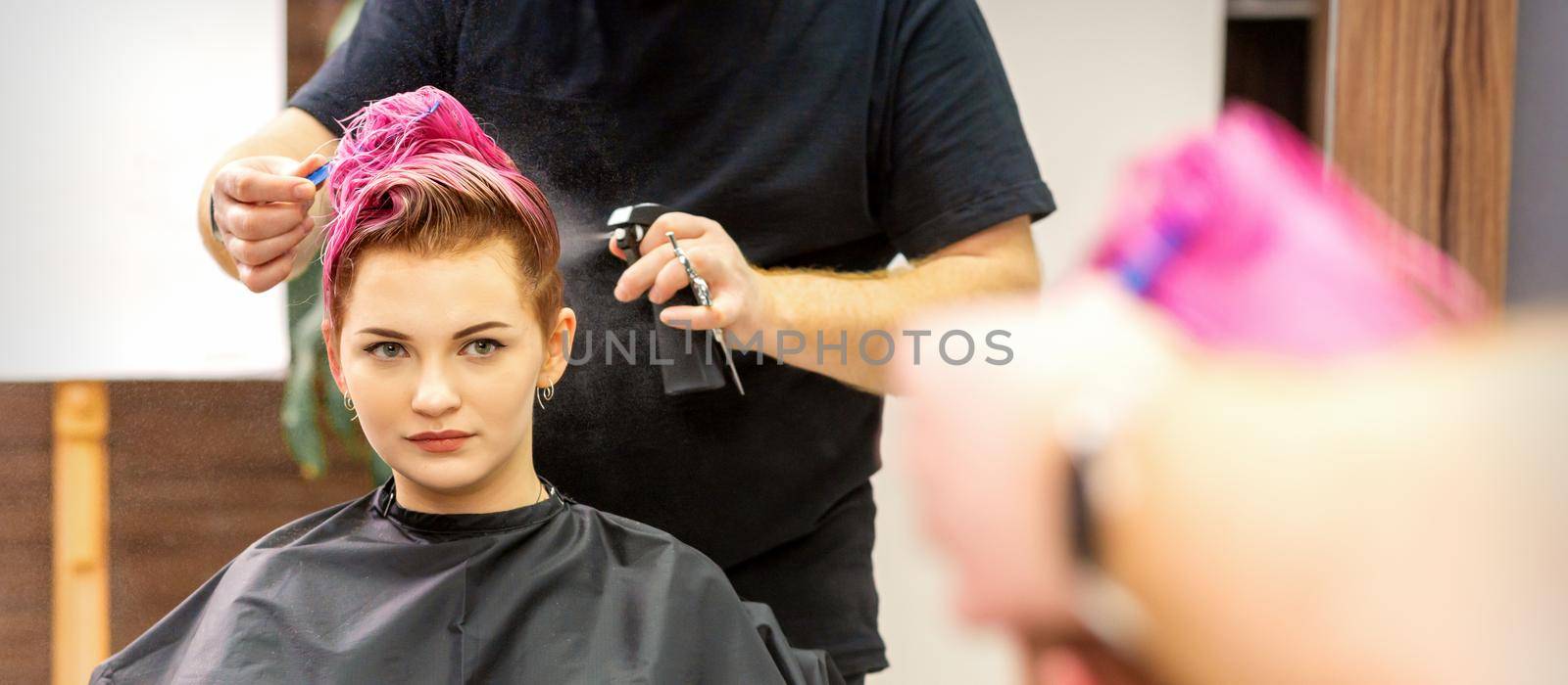 Beautiful young pink haired caucasian woman in the modern hair salon