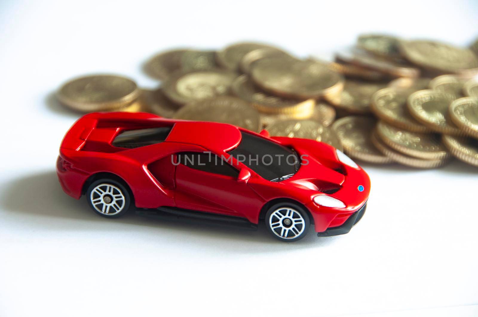Kuala Lumpur, Malaysia - September 2022 : Selective focus of miniature toy car of Ford GT on white cover background with blurred gold coins. Copy space.