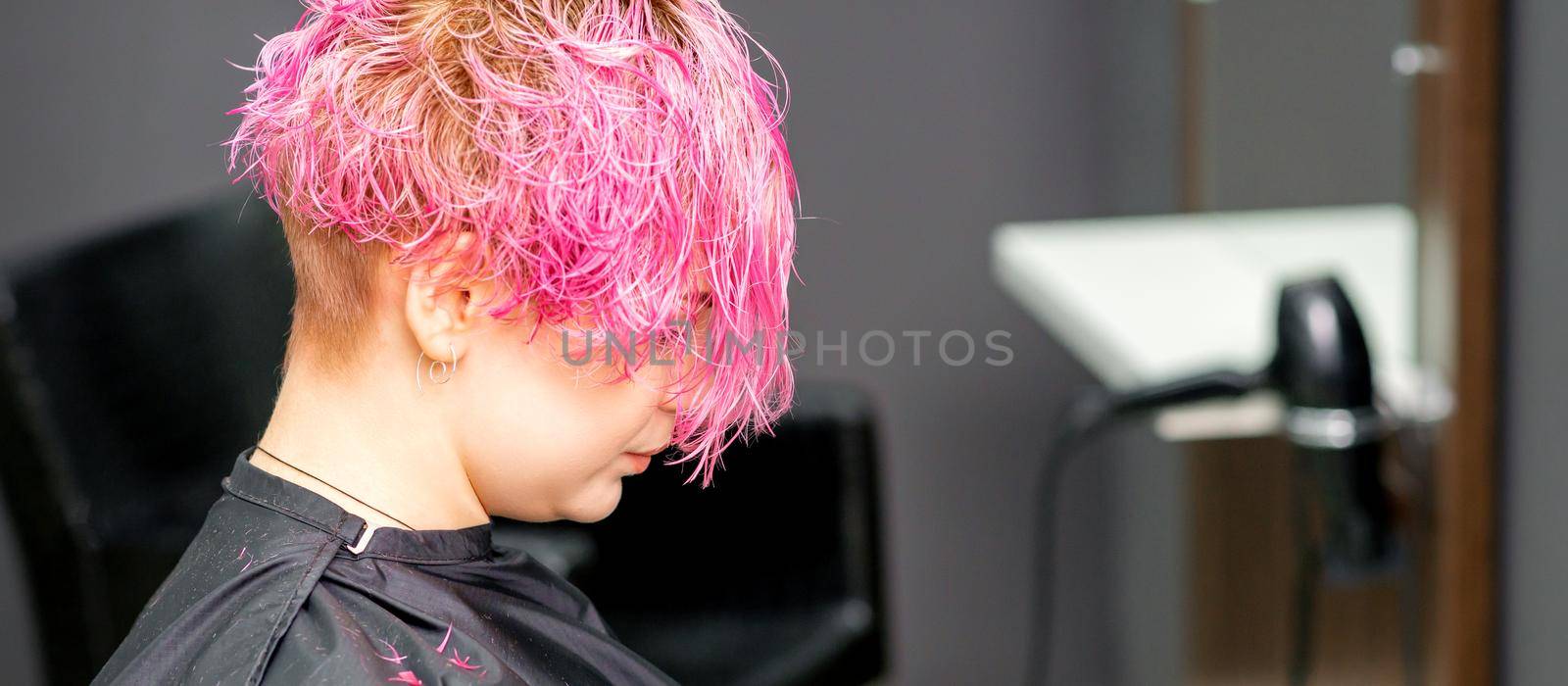 Beautiful young pink haired caucasian woman in the modern hair salon