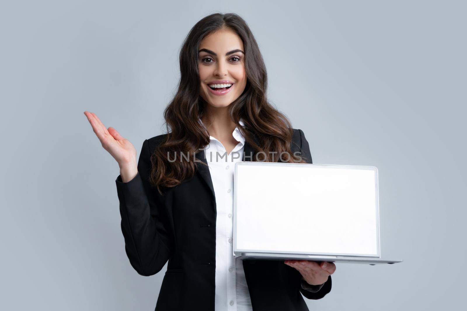 Woman holding laptop with empty mock up screen for copy space. Business women in suit excited something in laptop screen. Portrait of business lady holding notebook