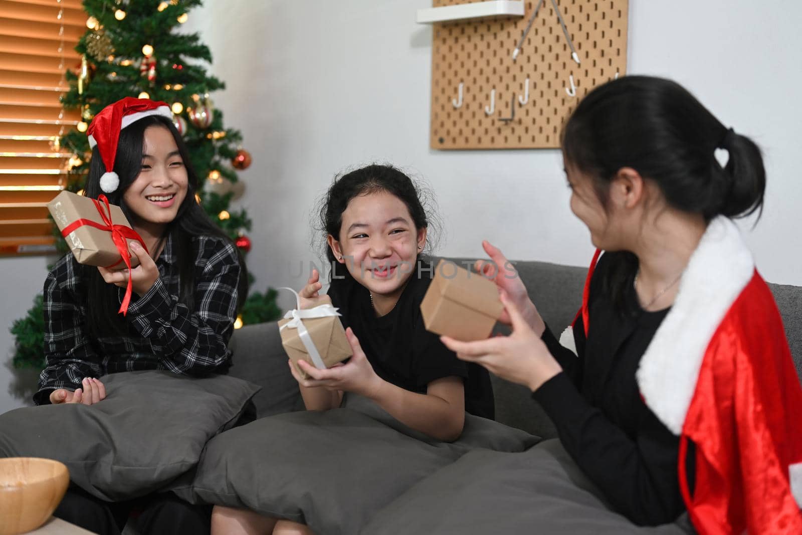Group of cheerful asian girls celebrating Christmas at home.