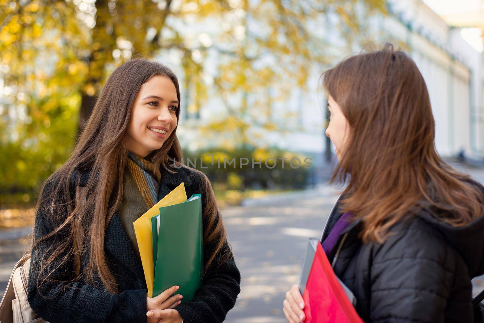 Studying concept. Two students girls near university by VitaliiPetrushenko