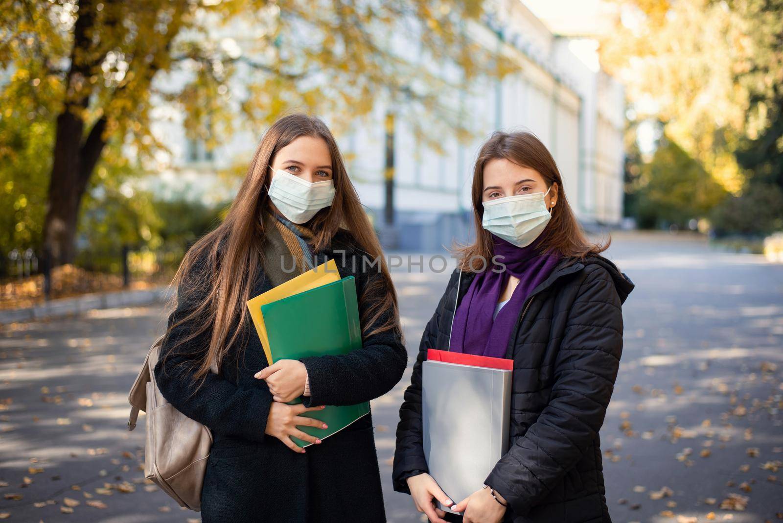 Two university students friends in medical masks going to classes in the morning by VitaliiPetrushenko