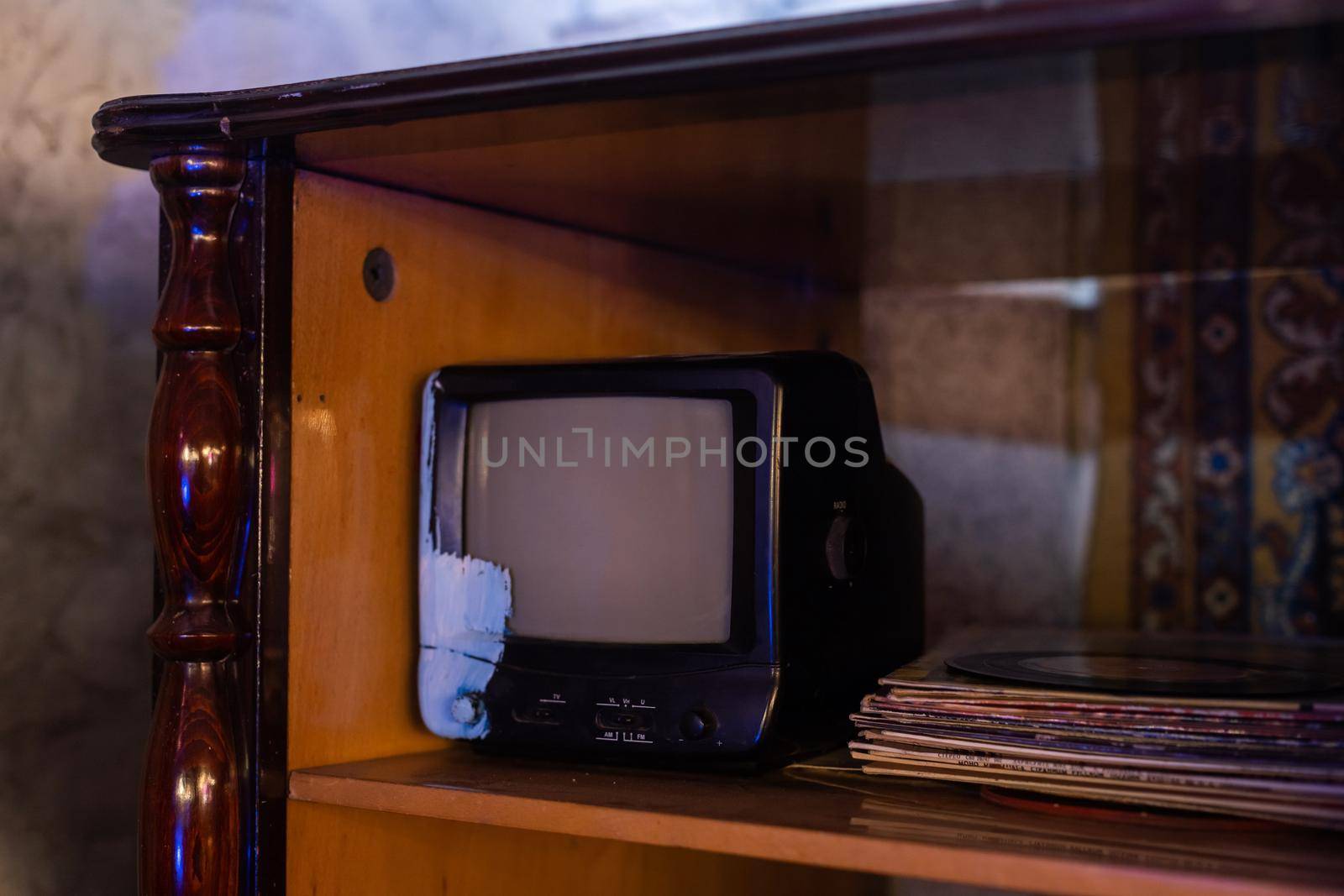 retro tv with wooden case in room with vintage wallpaper and parquet.
