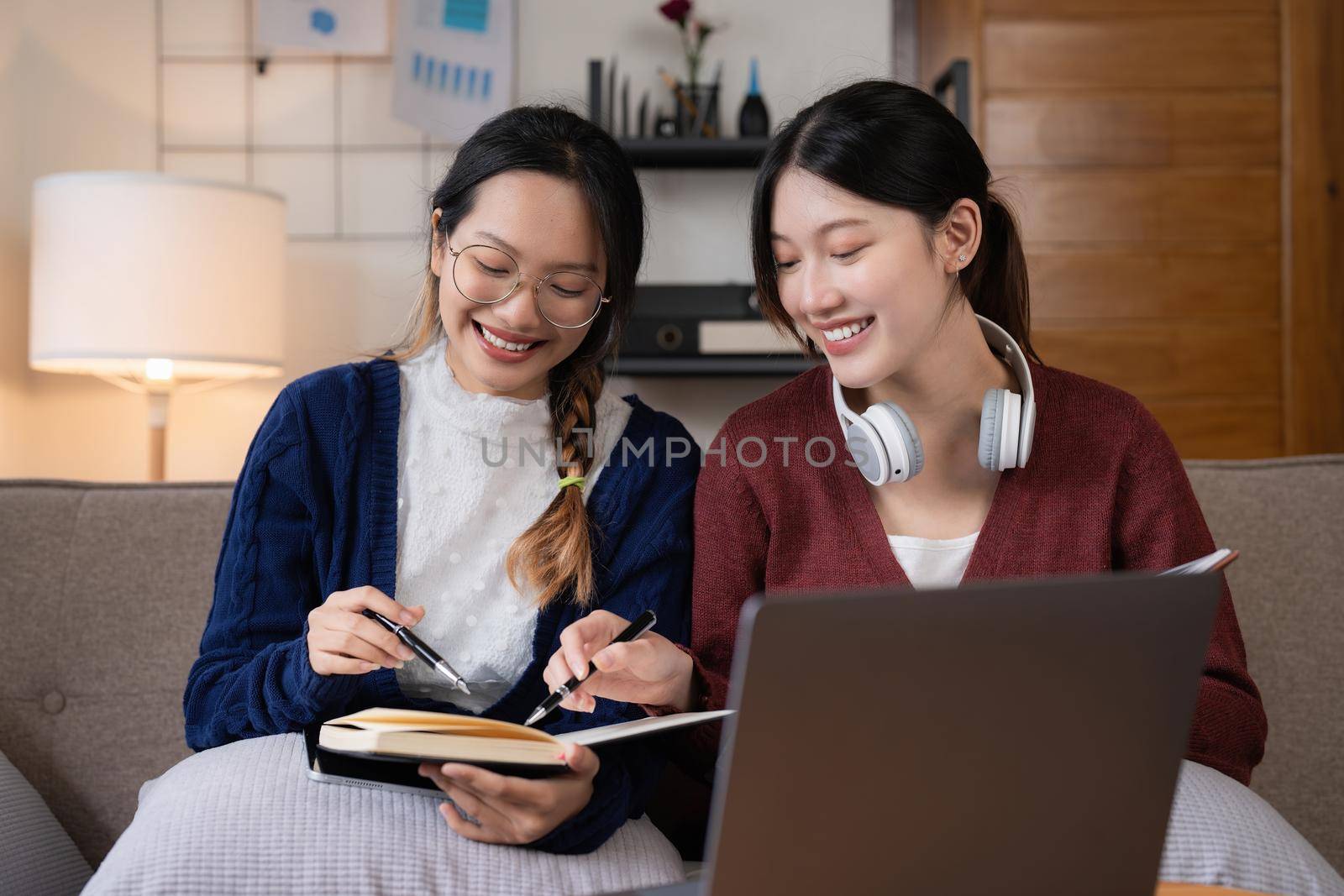 Two asian students learning together online with a laptop and tutor together at home by itchaznong