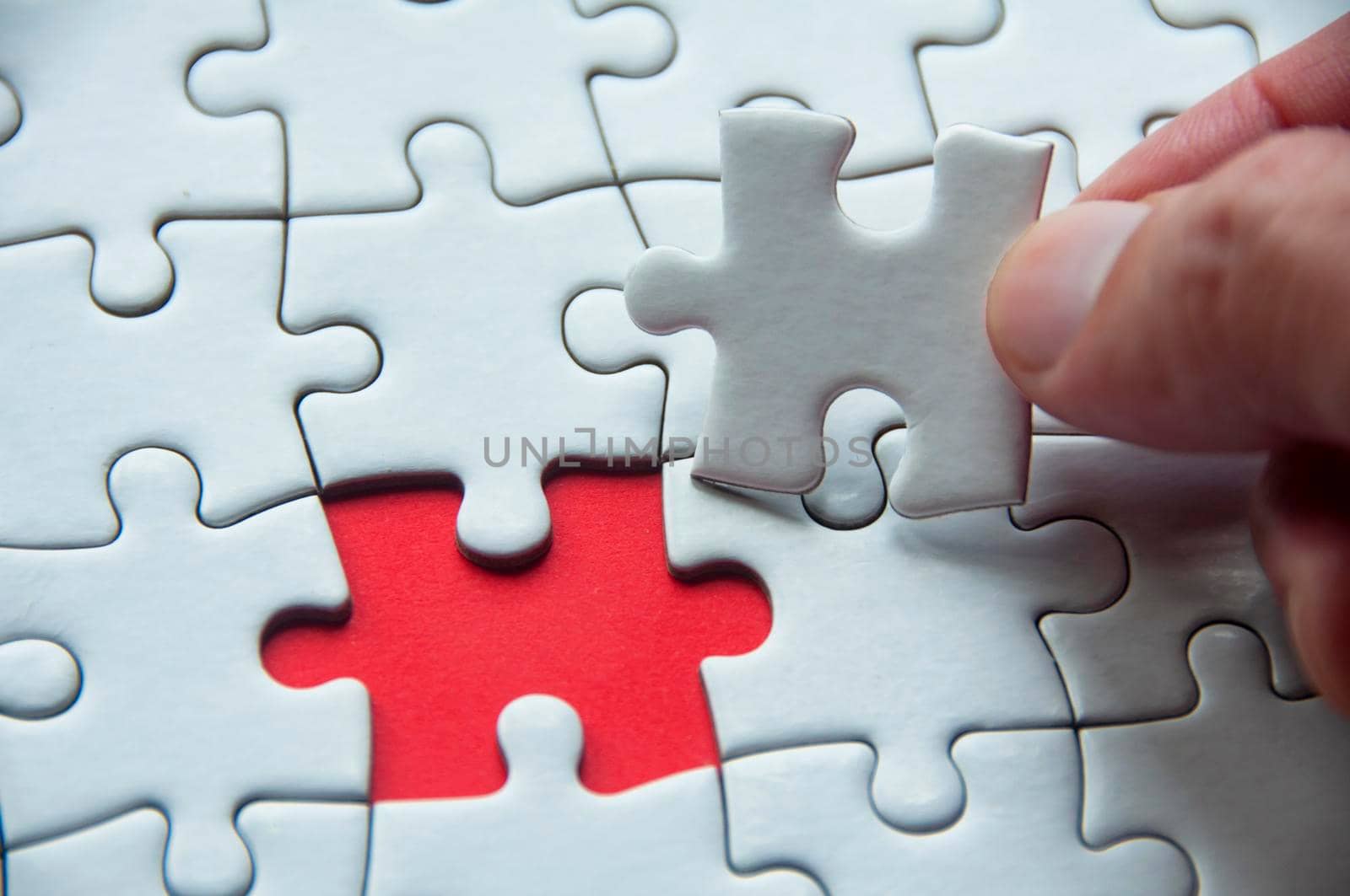 White jigsaw puzzle on red cover background with customizable space for text or idea. Copy space and puzzle concept.