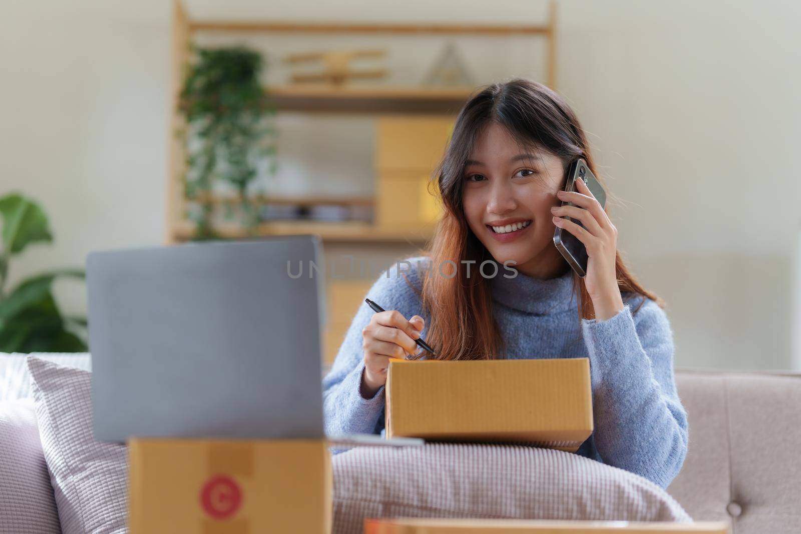 Asian SME business woman talking with client by phone at home office. online shopping concept.