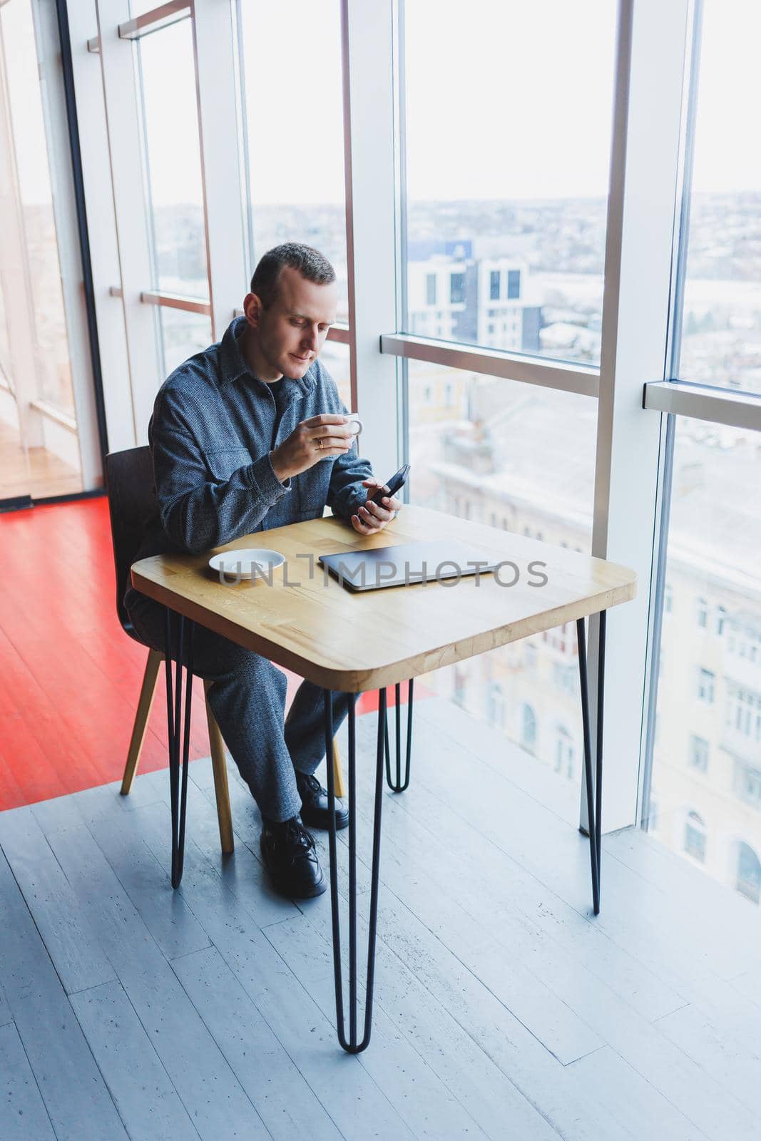Happy smiling male manager sitting in cafe using mobile phone gadget, ordering delivery service via online app, free 4g wireless network in cafe, cheerful freelancer texting on mobile phone