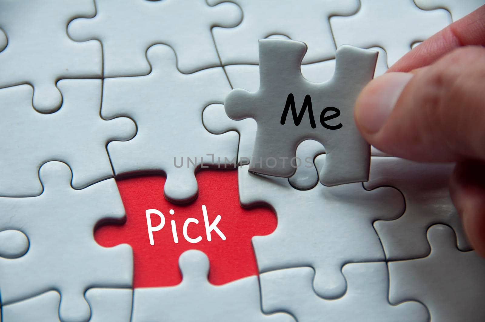 Pick me text on white jigsaw puzzle. Selection concept.