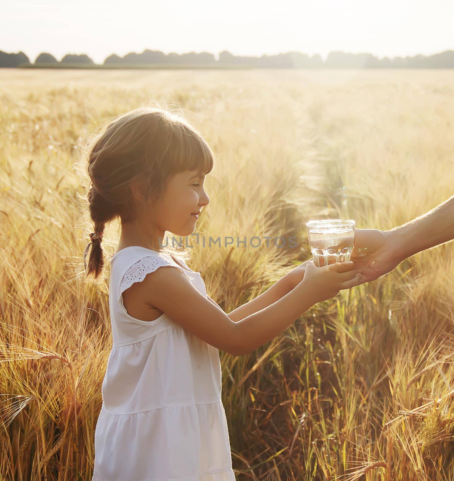The father gives the child a glass of water. Selective focus. by yanadjana