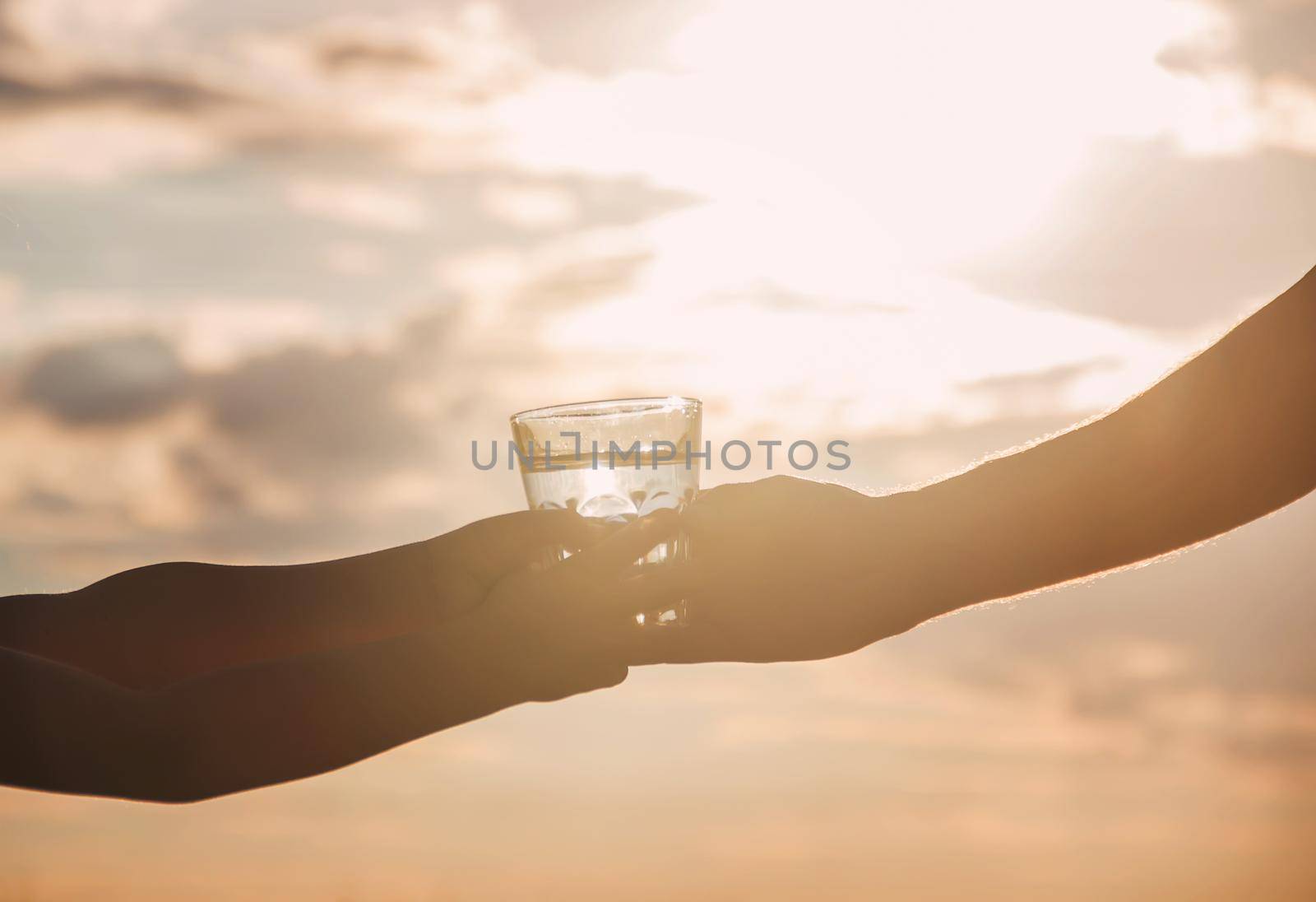 The father gives the child a glass of water. Selective focus. by yanadjana