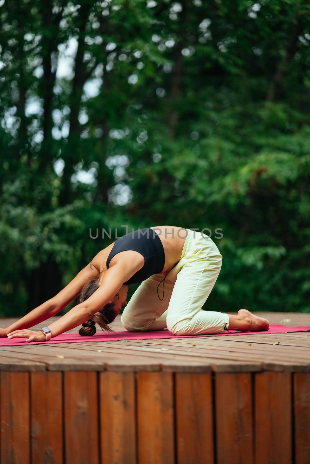 A young woman in doing yoga in the yard on the veranda
