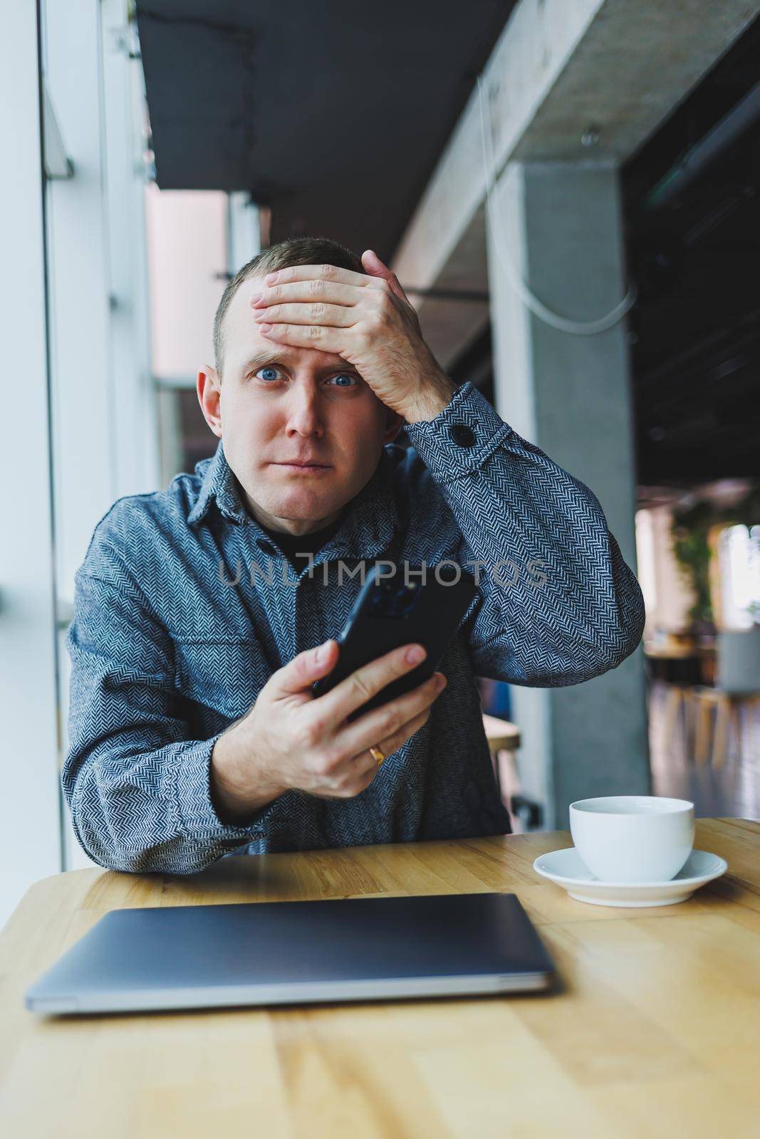 Excited young man in suit using mobile phone with funny expression, excited business man looking at his smartphone, reading good news via email, emotional lifestyle concept.