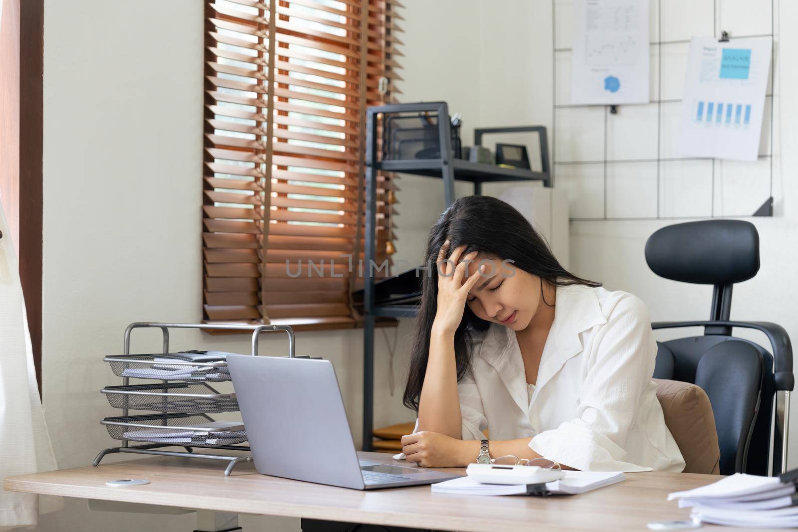 Tired business accountant woman feel headache. stressed working woman at business desk in a business office.