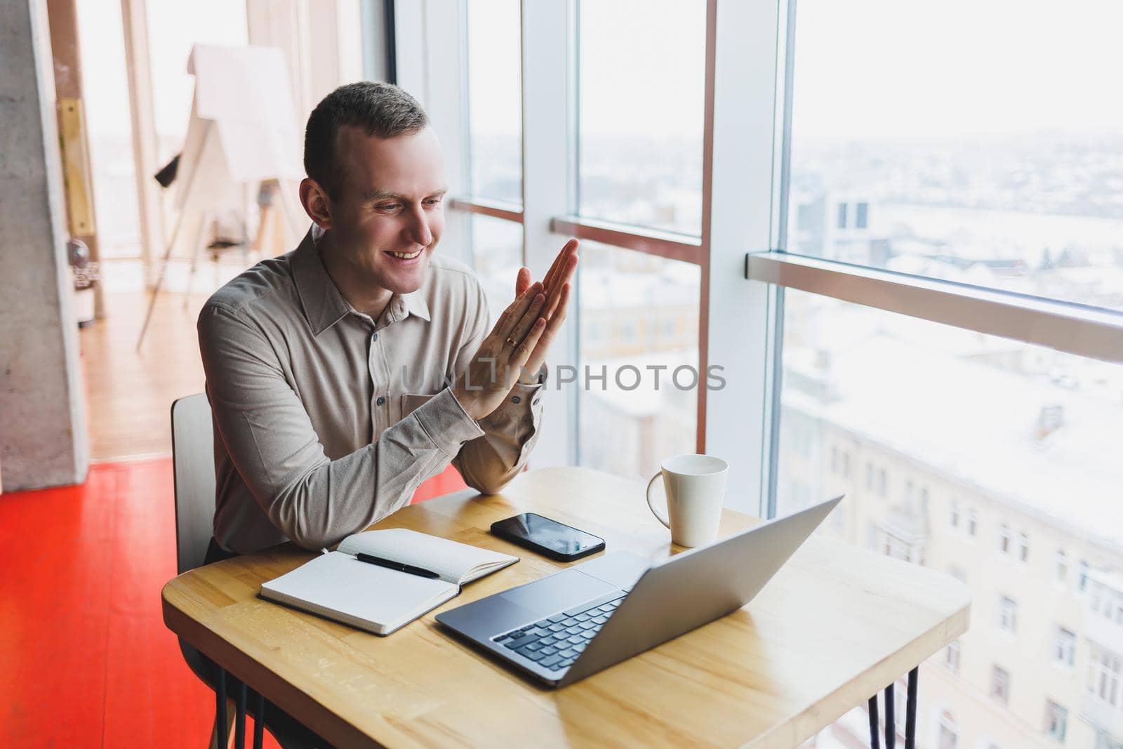 Intelligent young male using laptop to take notes during online education program, experienced male freelancer sitting with technology in cafe interior. Young businessman