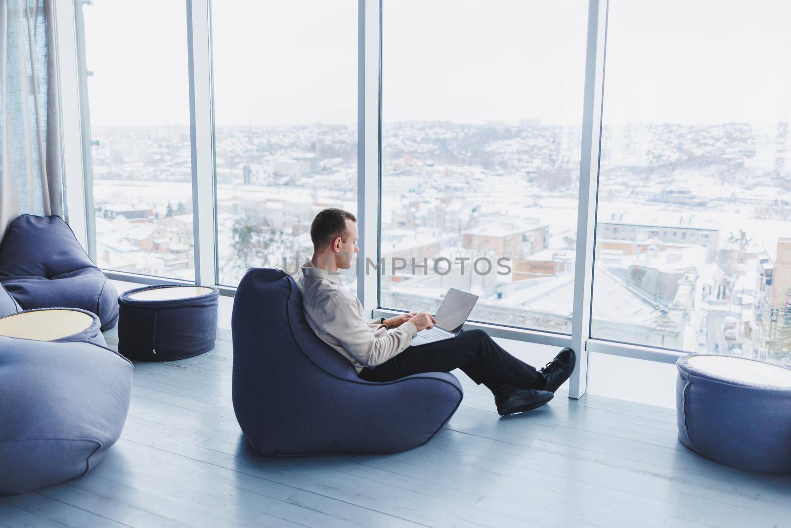 A successful businessman sits in a working cafe and works on an important project. Businessman is typing on a laptop. Businessman using laptop in cafe