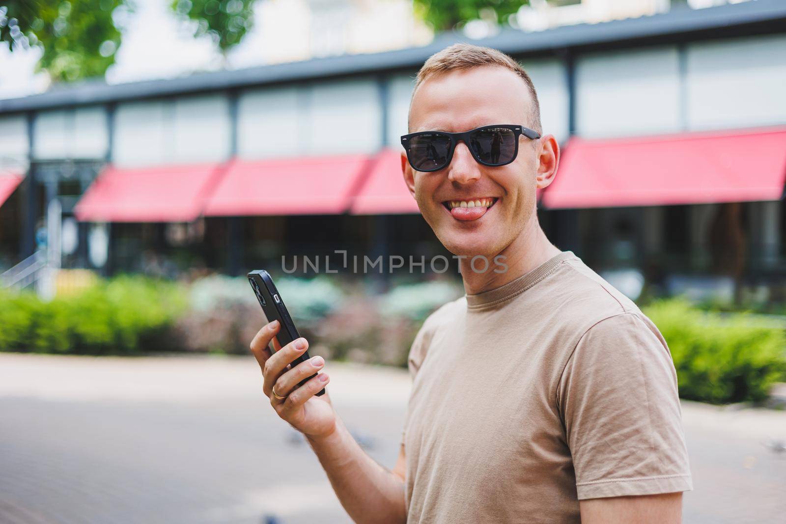 Man in shopping. Smiling man with shopping bags walking down the street. Consumerism, lifestyle concept