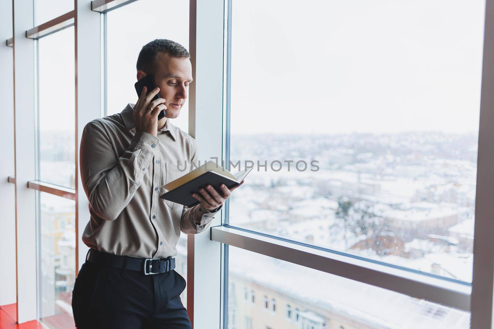 Work with papers. Serious male entrepreneur working in office alone, reading document in hard copy, thinking on terms. Focused young man doing paperwork editing agreement tex