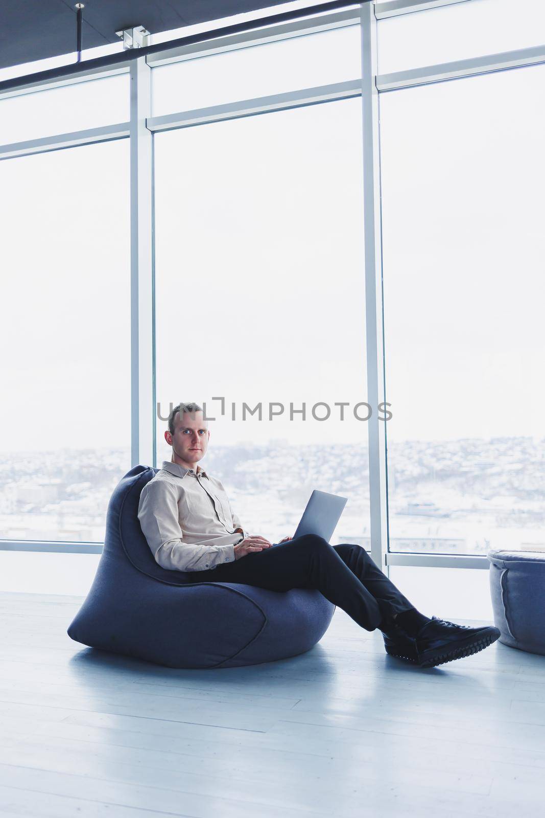 Young smart male businessman is sitting in the office and working on a project related to public cyber technology. Businessmen with laptop trying to meet deadlines in external marketing.