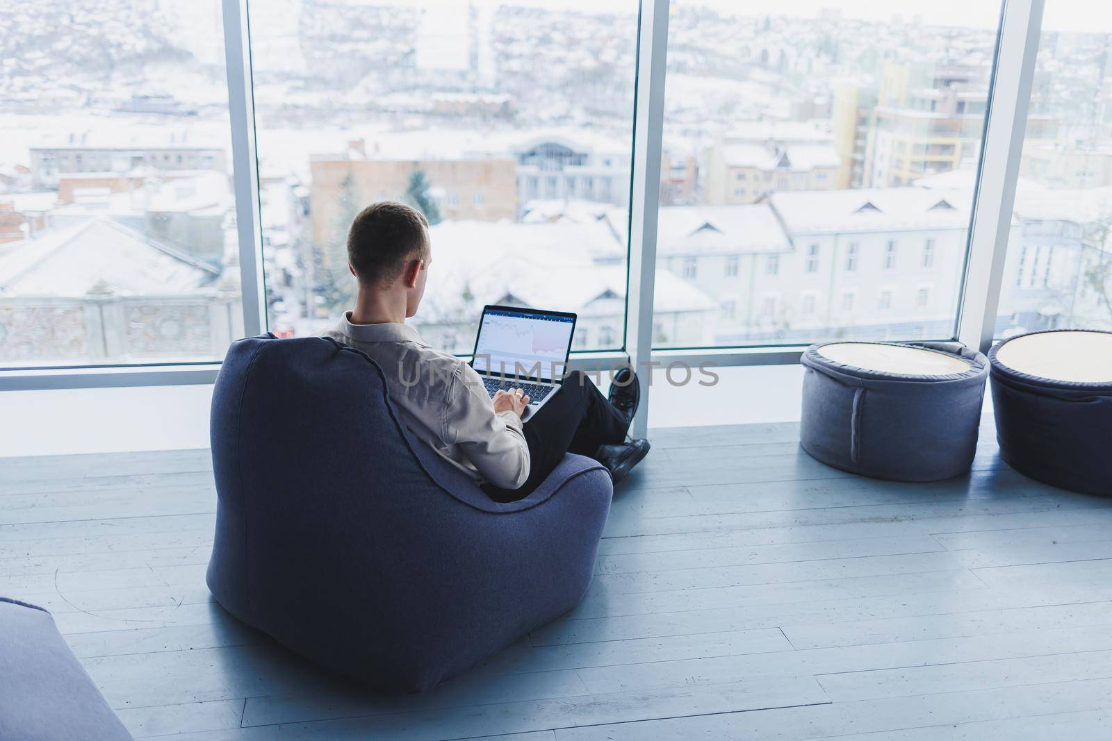 Young smart male businessman is sitting in the office and working on a project related to public cyber technology. Businessmen with laptop trying to meet deadlines in external marketing.