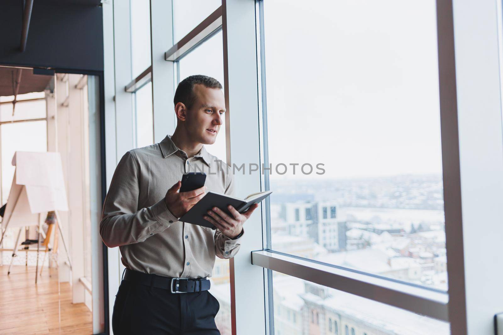 Work with papers. Serious male entrepreneur working in office alone, reading document in hard copy, thinking on terms. Focused young man doing paperwork editing agreement tex