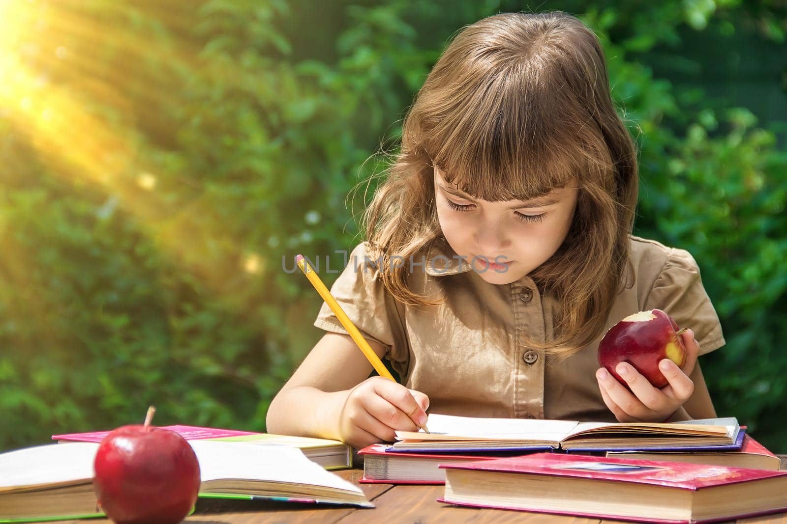 Child student with a red apple. Selective focus. by yanadjana