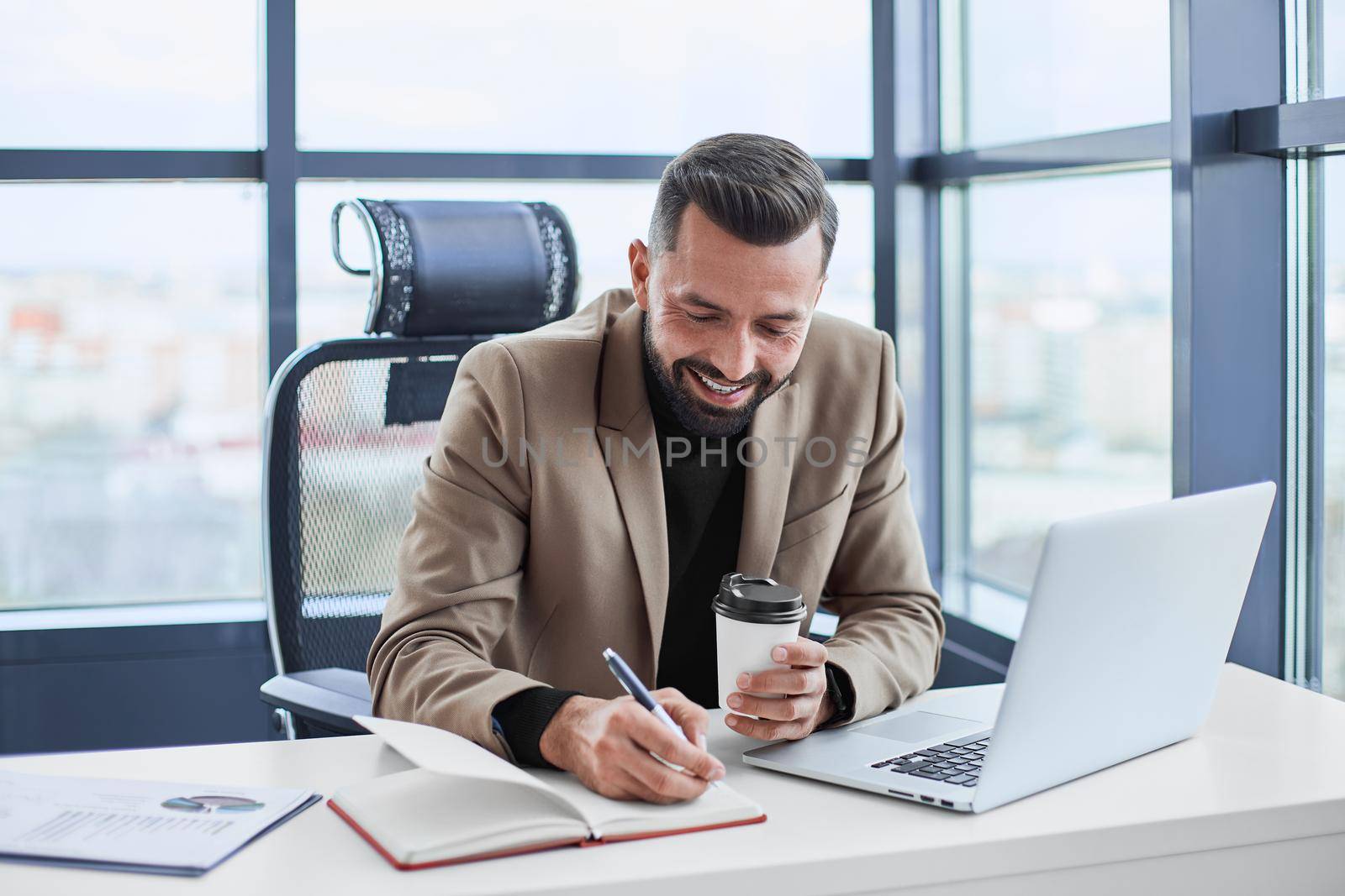businessman with takeaway coffee analyzing a financial document. close-up.