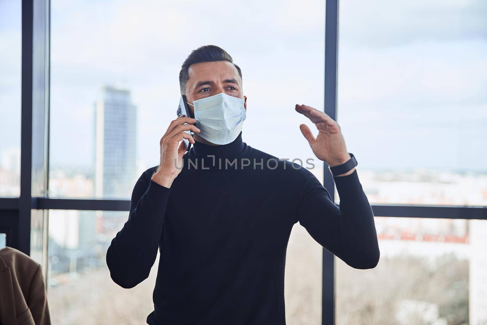 businessman in a protective mask communicating on a smartphone. close-up.