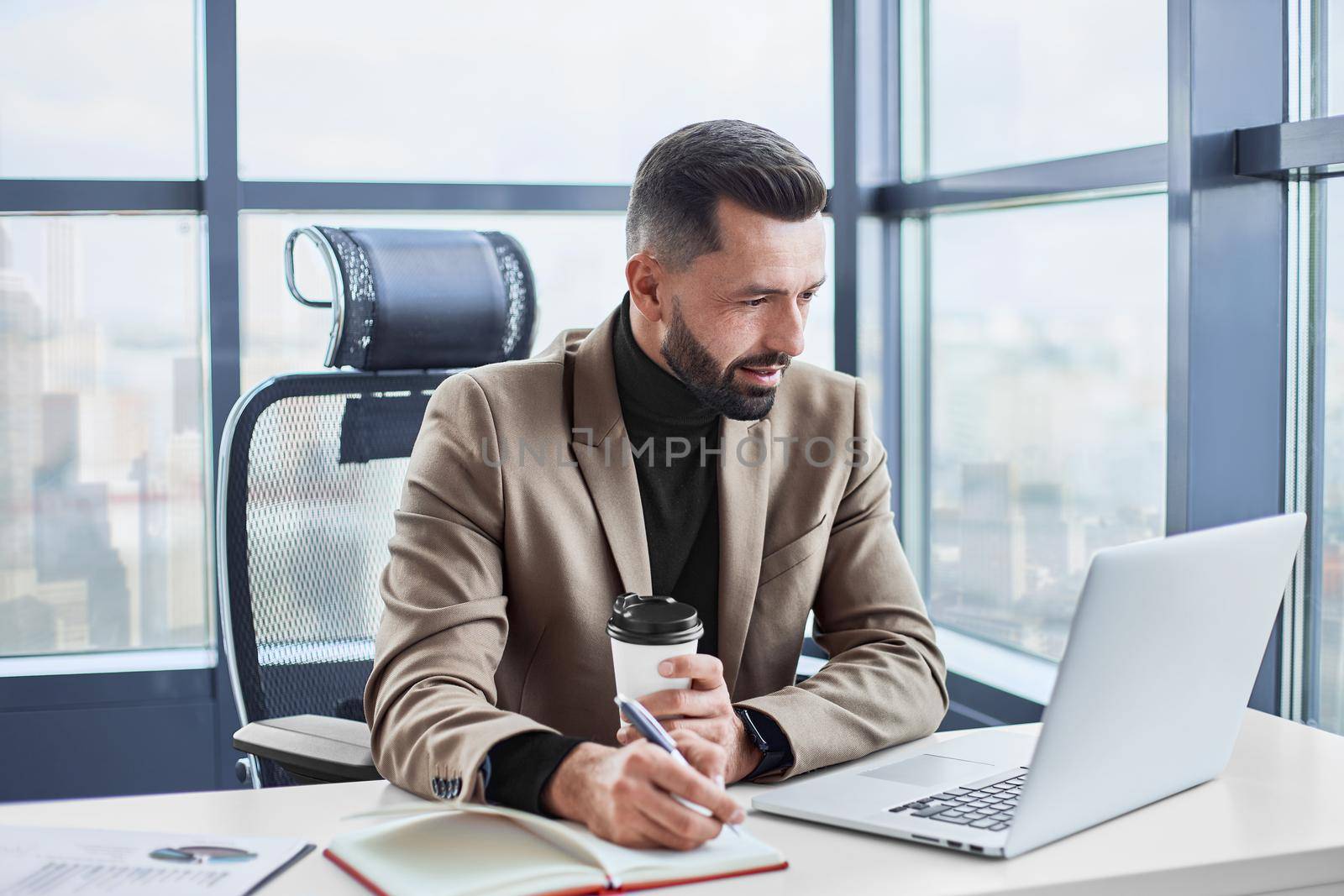 businessman with a takeaway coffee works with documents. by SmartPhotoLab