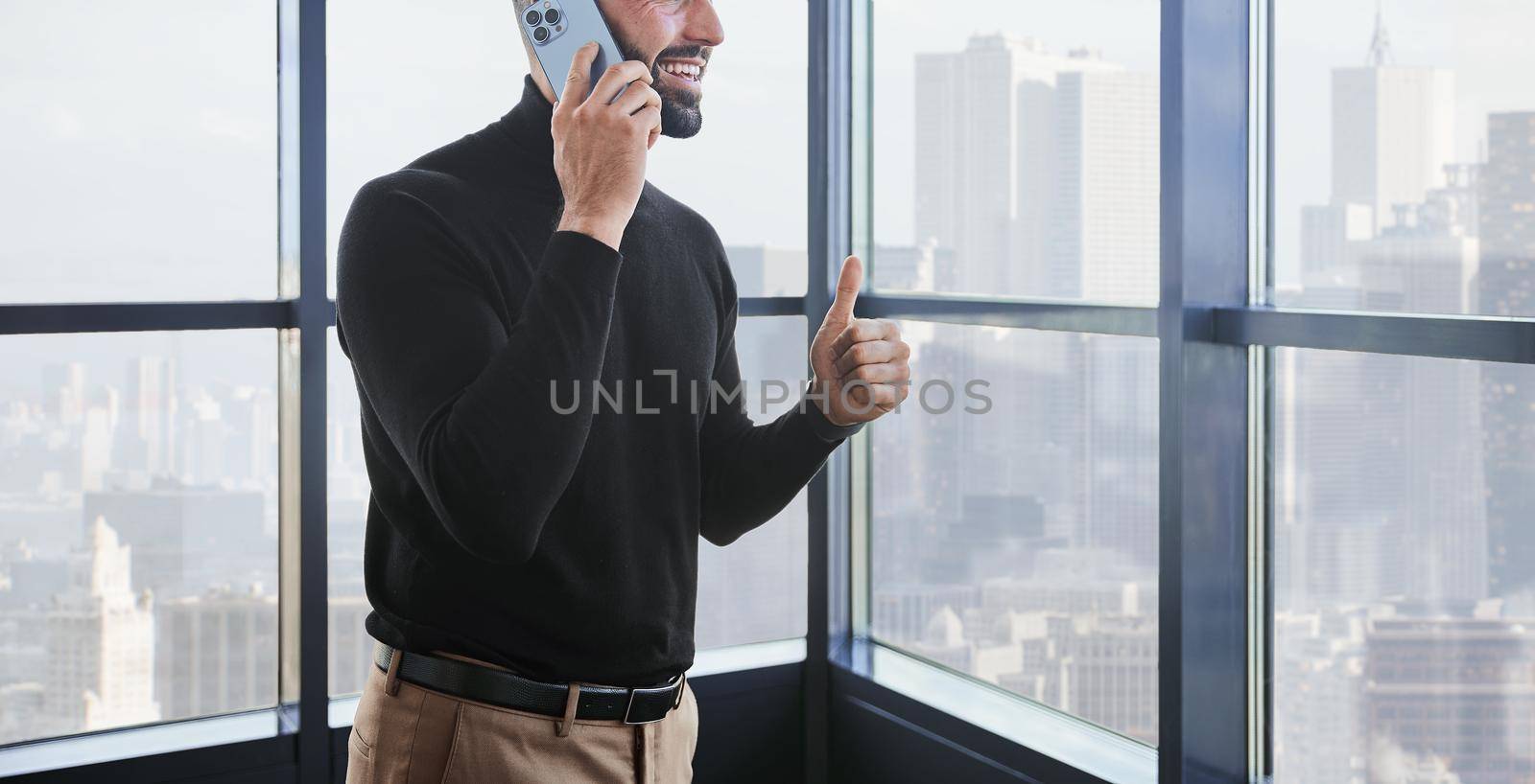 businessman gives a thumbs up. A person uses mobile technologies by SmartPhotoLab